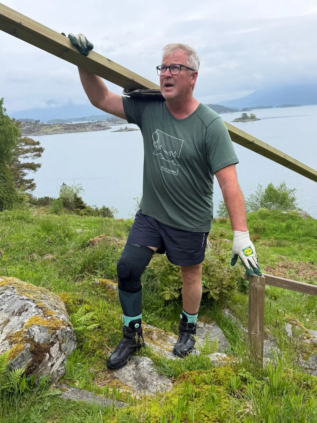 Arnt Ole Ingebretsen bærer en trestamme på skulderen i ulendt terreng på Tjørnøy i Ryfylke, med Wear'N'Go Ankle Trainer på føttene