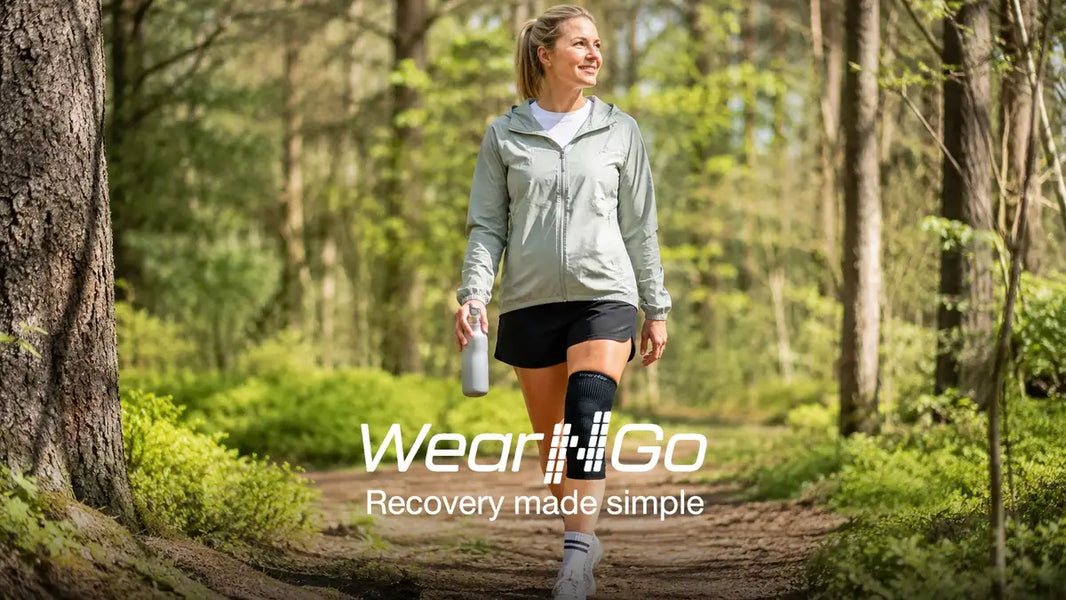 Norsk kvinne i 30-40-årene går tur i skog med Wear'N'Go Knestøtte på høyre kne, viser forebyggende bruk under aktiv hverdag i mai